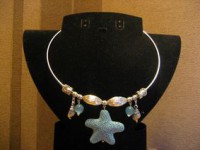 Gargantillas de cordón de metal  una con  abalorios de metal dorado y estrella de mar en gris y la otra con abalorios de cristal y estrella de mar ceramica blanca
